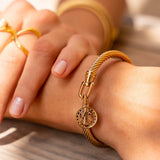Pulseira dourada com design de moeda