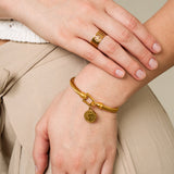 Pulseira dourada com design de moeda